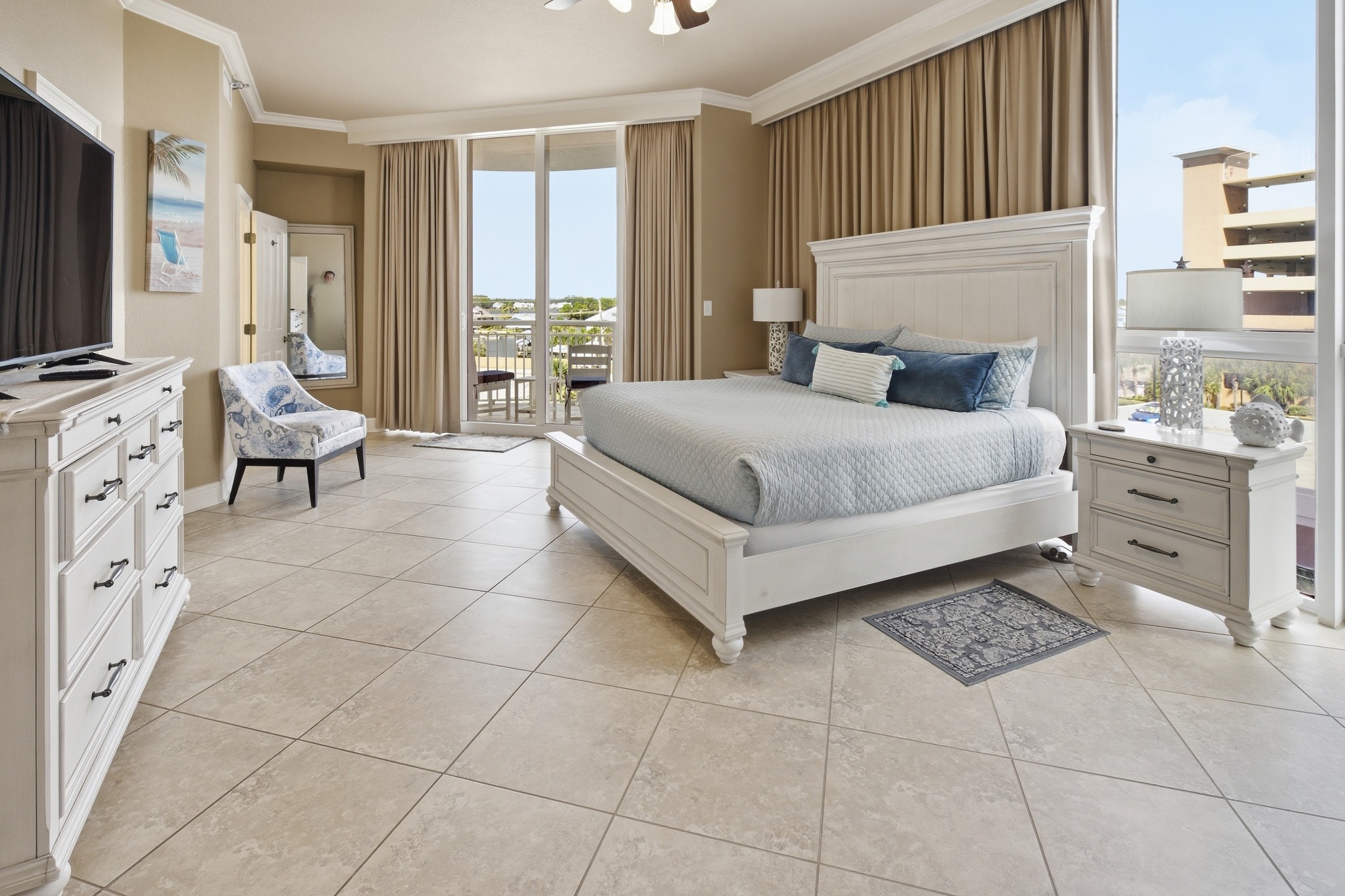 Coastal condo primary bedroom with balcony views
