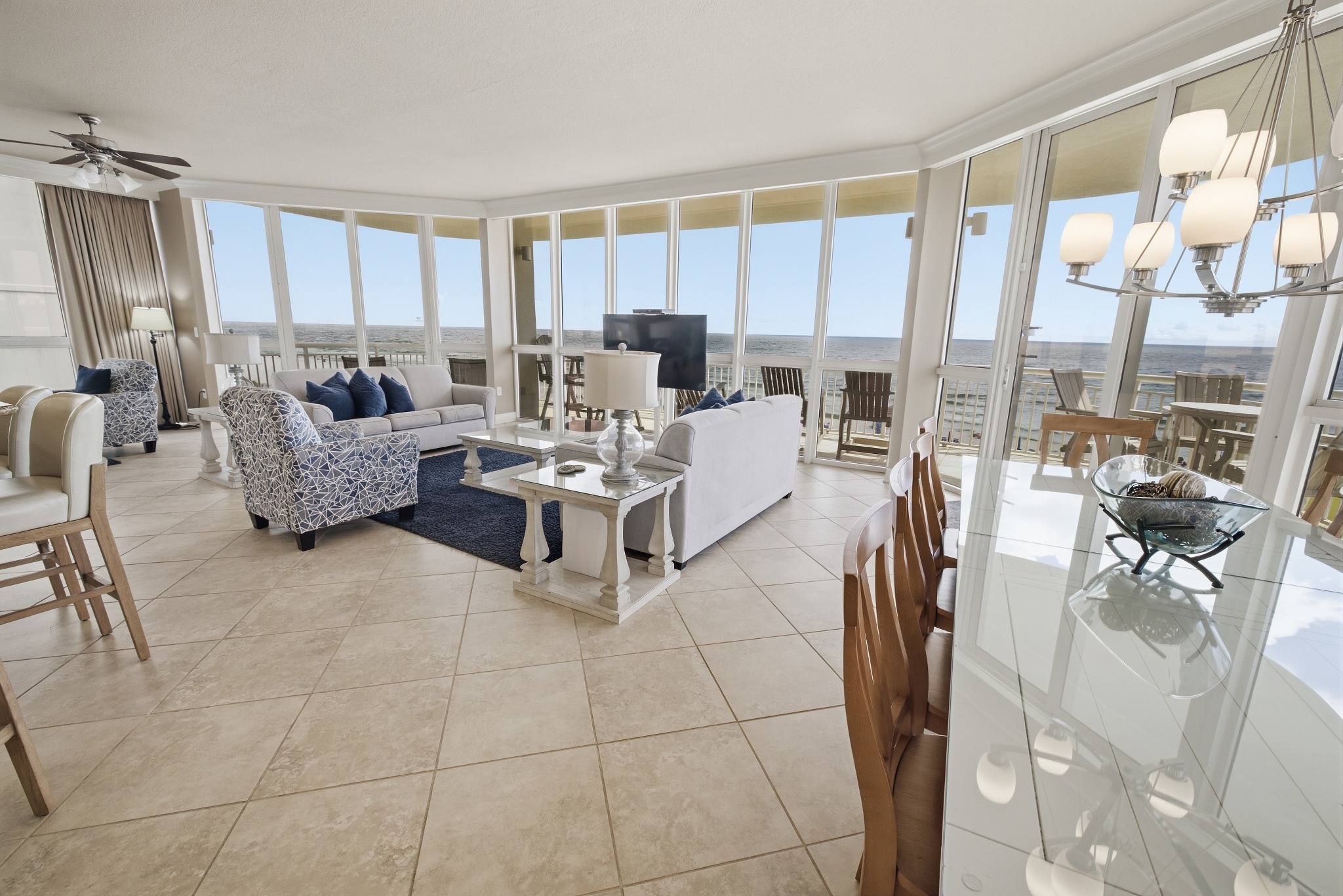 Coastal condo living and dining room with panoramic waterfront views
