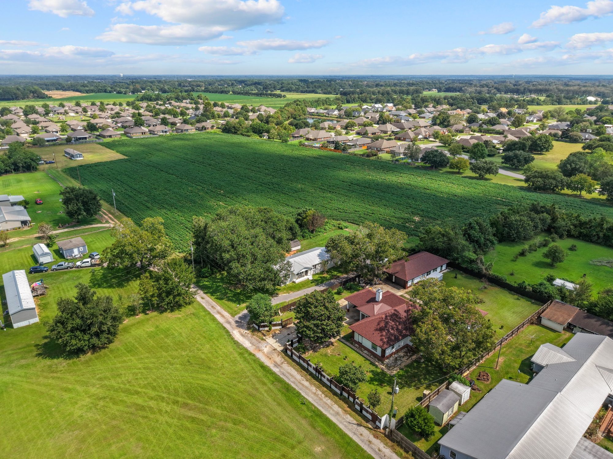 Aerial view of land and surrounding neighborhood